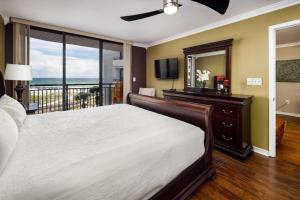 a bedroom with a bed and a television and a balcony at Nautilus 2407 Gulf View 2 Bedroom 4th Floor Free Beach Service in Fort Walton Beach