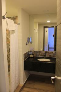 uma casa de banho com um lavatório e um espelho grande em Sawari Hotel em San Carlos