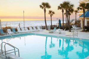 a large swimming pool with chairs and the beach at Total Remodel BEACHFRONT 5th Floor - 2 Bd & 2 Ba - Dunes of Panama in Panama City Beach