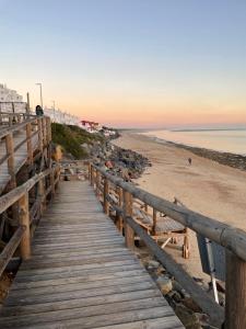 a wooden boardwalk leading down to the beach at Cosy 2BR flat in Nuevo Portil city centre in El Portil