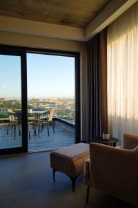 a room with a large window with a view of a patio at The Londoner Hotel Sliema in Sliema