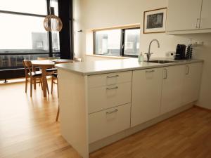 eine Küche mit einem Waschbecken und einem Tisch in einem Zimmer in der Unterkunft Stunning 1-Bedroom Apt with Breathtaking Scenery in Tórshavn