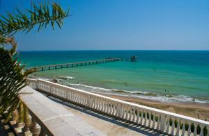 a pier on the beach with people in the water at Apartment Lermontov in Burgas