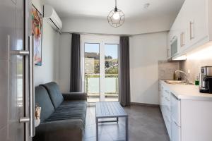 a living room with a couch and a kitchen at Nereides - Skinaria Beach Apartment in Damnoni