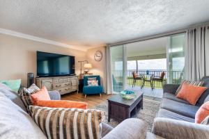 a living room with a couch and a tv at The Location! Aloha Soul Beachfront in Laie