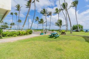 a picnic table in a park with palm trees at The Location! Aloha Soul Beachfront in Laie