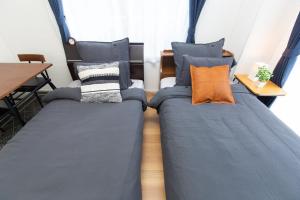 two beds in a room with blue and orange pillows at Amber Iidabashi - Vacation STAY 90475v in Tokyo