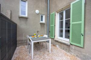 einem Tisch vor einem Gebäude mit grünen Rollläden in der Unterkunft Appartement avec terrasse et parking, à Meaux in Meaux