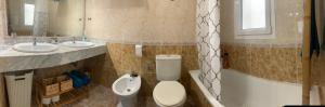 a bathroom with a toilet and two sinks and a tub at Apartamento La Menia - Cabo Roig in Orihuela Costa +16 photos