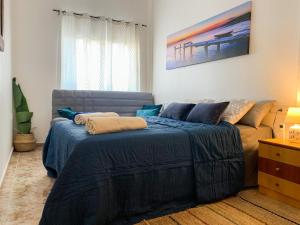 a bedroom with a blue bed and a couch at Apartamento La Menia - Cabo Roig in Orihuela Costa