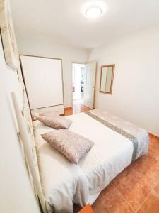 a bedroom with a bed with two pillows on it at Piscina & Wifi. SUNNY apartement, swimming pool. in Caleta De Fuste