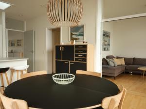 einen schwarzen Tisch und Stühle im Wohnzimmer in der Unterkunft Stunning 1-Bedroom Apt with Breathtaking Scenery in Tórshavn