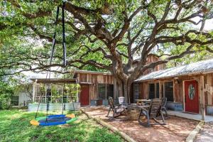 una casa con un árbol, una mesa y sillas en Pet Friendly! Hot Tub, 2mins from Main, Fire Pit, en Fredericksburg