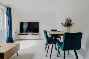 a living room with a table and chairs and a television at stylish apartment in Bournemouth