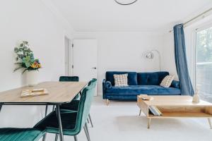 a living room with a blue couch and a table at stylish apartment in Bournemouth