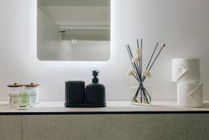 a bathroom counter with a bottle of soap and a mirror at stylish apartment in Bournemouth +20 photos