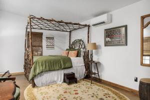 a bedroom with a bed with a metal canopy at Pet Friendly Treehouse Vibe with Hot Tub & Fire Pit in Fredericksburg
