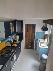 a small kitchen with a stove and a sink at Telagraph cottage in Penzance