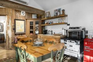 a kitchen with a wooden table and a stove at Pet Friendly Treehouse Vibe with Hot Tub & Fire Pit in Fredericksburg
