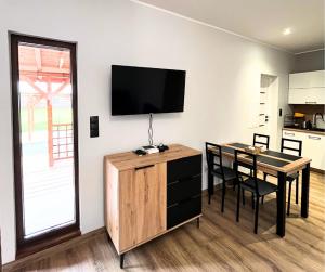a living room with a table and a television on a wall at Rajcuś in Rajcza