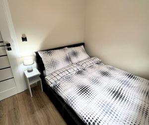 a bedroom with a black and white bed with a side table at Rajcuś in Rajcza
