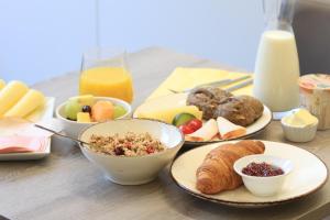 a table with plates of breakfast foods and drinks at Chambres4you in Namur