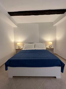 ein Schlafzimmer mit einem großen Bett mit einer blauen Decke in der Unterkunft Terrazzo sullo Ionio in Nova Siri