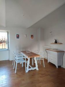 une salle à manger avec une table, des chaises et un comptoir dans l'établissement L'angolo delle rose, à Govone