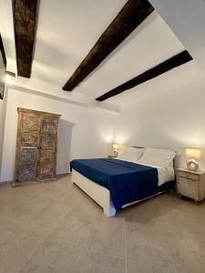ein Schlafzimmer mit einem großen Bett mit einer blauen Decke in der Unterkunft Terrazzo sullo Ionio in Nova Siri