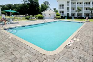 a large swimming pool with blue water in front of a building at River Oaks 40D in Myrtle Beach