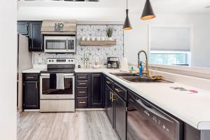 a kitchen with black cabinets and a sink at River Oaks 40D in Myrtle Beach