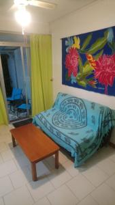 1 dormitorio con 1 cama, 1 mesa y 1 pintura en Chez Caroline, en Basse-Terre