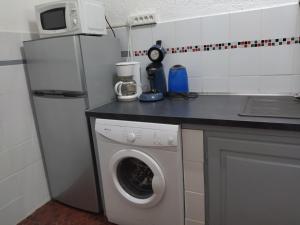 a kitchen with a refrigerator and a washing machine at Chez Caroline in Basse-Terre