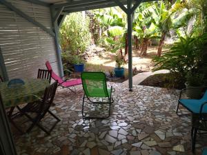 eine Terrasse mit Stühlen und einem Tisch auf der Terrasse in der Unterkunft Chez Caroline in Basse-Terre