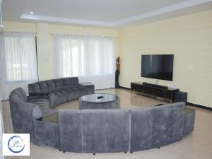Villa Anastasia في سيافونغا: غرفة معيشة مع كنب وتلفزيون بشاشة مسطحة