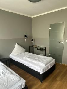 una camera con 2 letti e una porta scorrevole in vetro di Hotel Fly ´ In a Offenbach