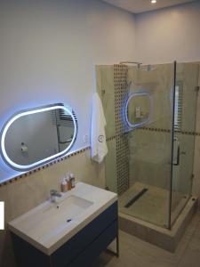 a bathroom with a shower and a sink and a mirror at Villa Anastasia in Siavonga