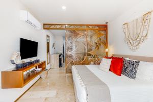 a bedroom with a large bed and a tv at Perfect Place 302 in Playa del Carmen