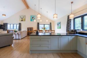 a kitchen with white cabinets and a large island at Sunset Barn in Dulverton