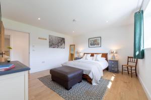 a bedroom with a bed and a stool in it at Sunset Barn in Dulverton