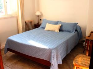 a bedroom with a bed with a blue comforter at Hotel Medina B&B in Mar del Plata