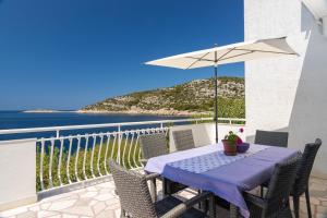 a table with an umbrella on a balcony with the ocean at Villa Planka Pearl in Ražanj