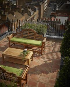 two wooden benches sitting on a brick patio at Batty Langley's in London