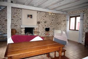 sala de estar con mesa de madera y chimenea en Le chambery, en Saint-Junien