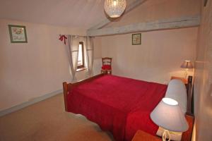 1 dormitorio con cama roja y manta roja en Le chambery, en Saint-Junien