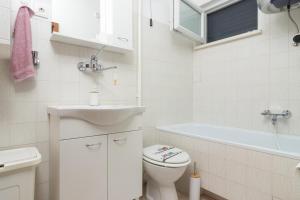 La salle de bains est pourvue de toilettes, d'un lavabo et d'une baignoire. dans l'établissement Villa Planka Pearl, à Ražanj