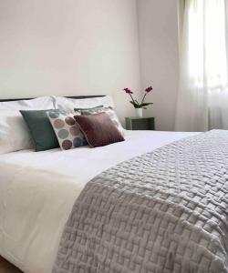 1 dormitorio con cama blanca y almohadas en Lakeside View Colico en Colico