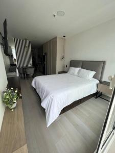 ein Schlafzimmer mit einem großen weißen Bett in einem Zimmer in der Unterkunft Sky View Studio - Best Area Quito in Quito
