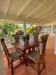 una mesa de madera y sillas en un porche en Casa yaan, en Las Galeras