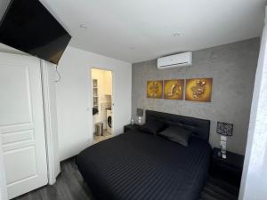 a bedroom with a black bed in a room at Appart de Luxe tout confort jusqu a 4 personnes in Triel-sur-Seine